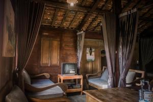 a living room with two chairs and a tv at Sekar Gambir Homestay in Batu