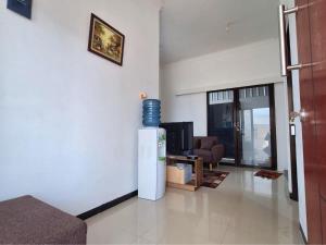 ein Wohnzimmer mit einem TV und einem Sofa in der Unterkunft Villa Harga Ekonomis di Malang in Malang