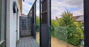 an open door of a house with a fence at Cambridge Stays Riverside 2BR Flat-Walk to Centre-Parking-Balcony in Cambridge