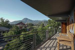 a balcony with a bench and mountains in the background at Sekar Gambir Homestay in Batu
