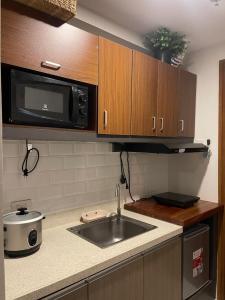 a kitchen with a sink and a microwave at MG’s PLACE at Horizons 101 in Cebu City