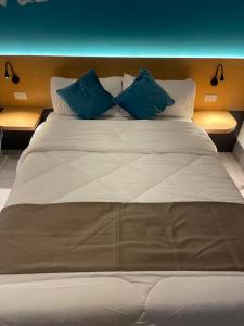 a large bed with two blue pillows on it at MG’s PLACE at Horizons 101 in Cebu City