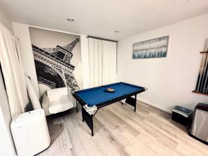 a pool table in a room with a picture of the eiffel tower at Amazing Large 2 Bedroom West Hollywood Apartment in Los Angeles