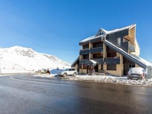 a building with cars parked outside of it in the snow at Studio Saint-Lary-Soulan, 1 pièce, 5 personnes - FR-1-296-492 in Saint-Lary-Soulan