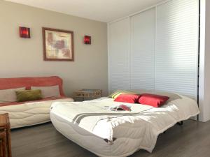 um quarto com 2 camas e almofadas vermelhas em Appartement Le Lavandou, 2 pièces, 4 personnes - FR-1-251-581 em Le Lavandou