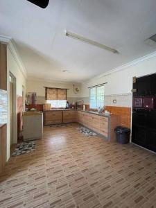 a large kitchen with wooden flooring and a large room at MP Homestay Lost world of tambun in Kampong Batu Lapan