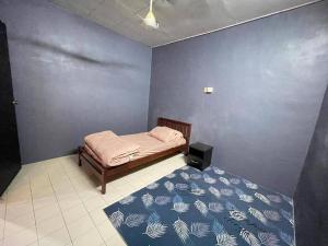 a bedroom with a bed with a blue wall at MP Homestay Lost world of tambun in Kampong Batu Lapan