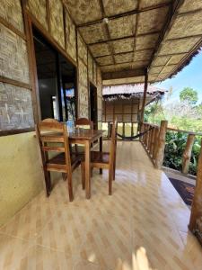 a dining room with a wooden table and chairs at Cecilia's Guest House in Siquijor