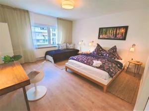 ein Schlafzimmer mit einem Bett und einem Sofa in einem Zimmer in der Unterkunft Zwei Zimmer Wohnung Nähe Bahnhof in Karlsruhe