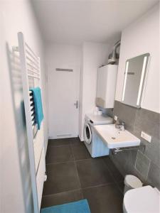 ein Badezimmer mit einem Waschbecken und einer Waschmaschine in der Unterkunft Zwei Zimmer Wohnung Nähe Bahnhof in Karlsruhe