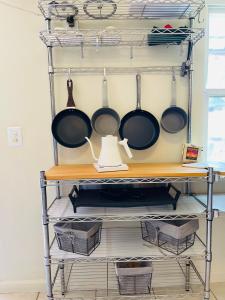 a kitchen rack with pots and pans on it at Quaint Historic Cottage in Downtown Phoenix in Phoenix