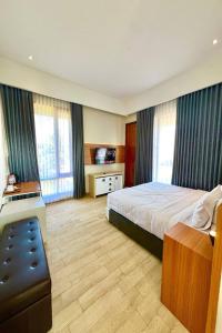 a hotel room with a bed and a television at The Royal Joglo in Tepus