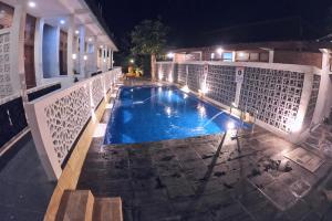 a swimming pool in the middle of a building at night at The Royal Joglo in Tepus