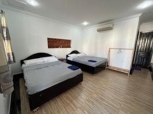 a room with two beds and a table in it at Errol's Homestay and Hostel in Siem Reap