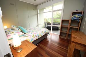 - une chambre avec un lit, une table et une fenêtre dans l'établissement Little Bay Cottage - 8 East Street Arakoon, à Arakoon