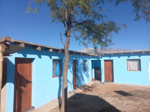 een blauw huis met een boom ervoor bij Casa de familia in Cachí