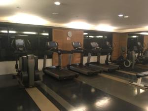 a gym with a row of treadmills and machines at Amari Residence in Khao Tao