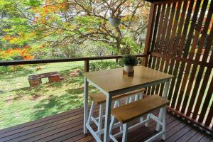 una veranda con tavolo e 2 sedie su una terrazza di Serenity View Studio Retreat a Woombye