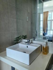 y baño con lavabo blanco y espejo. en Southbay Seaview Condo A16 #10minQueensbay #15minSPICE, en Bayan Lepas