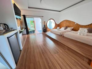 ein Wohnzimmer mit 2 Betten und Holzboden in der Unterkunft Lala Villa Koh Larn in Ko Larn