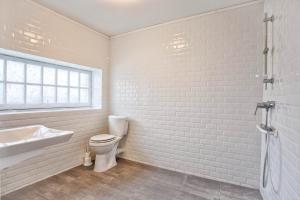 a white bathroom with a toilet and a sink at La Suite Mucha - Manoir des Marronniers VI in Sully