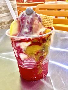 a plastic cup filled with ice cream and fruit at Casa Mango in Cali