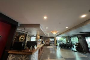 a lobby of a restaurant with a counter and chairs at Eurna Resort Hotel in Bangkok