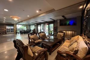 a living room with couches and a table and chairs at Eurna Resort Hotel in Bangkok