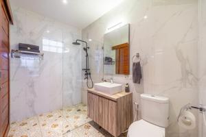 a bathroom with a toilet and a sink and a mirror at Villa Lebah - Tranquil Paradise of 3 bedroom Heart of Seminyak in Seminyak