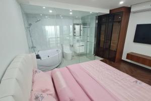 1 dormitorio con cama rosa, bañera y ducha en Penthouse Cao Cấp Tại Hà Nội, en Hanói