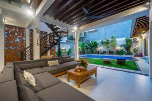 a living room with a couch and a table at Villa Lebah - Tranquil Paradise of 3 bedroom Heart of Seminyak in Seminyak