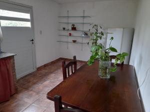 una mesa de madera en una cocina con un jarrón. en Dpto del Sur en San Roque