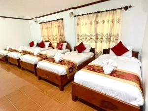 a group of four beds in a room at SISAVANG HOTEL in Vang Vieng