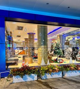 Una vetrina del negozio di Natale con un albero di Natale dentro. di Flipper Lodge Hotel - SHA Extra Plus a Centro di Pattaya