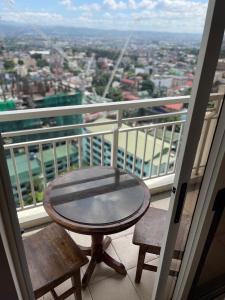 a table and two chairs on a balcony with a view at Cubao Infina Towers 2121 NT in Manila