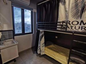 Baño con litera con lavabo y ventana en Yootel Hostel, en Hangzhou