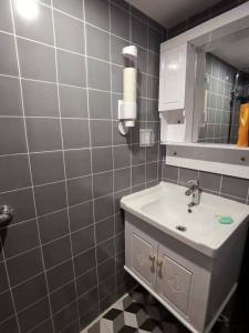 La salle de bains est pourvue d'un lavabo et d'un miroir. dans l'établissement Yootel Hostel, à Hangzhou