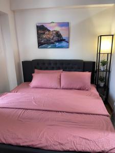 a bed with a pink comforter in a bedroom at Cubao Infina Towers 2121 NT in Manila