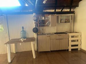 a kitchen with a table with a bottle on it at Punta Arena EcoHostal & EcoFit 01 in Playa Punta Arena