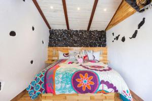 a bedroom with a bed with a colorful bedspread at Traditional Canary Cottage in Masca in Masca