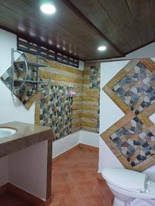 uma casa de banho com um WC e uma parede em mosaico em Lanta Mermaid Resort em Ban Ai Dao