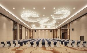 duża sala konferencyjna z długim stołem i żyrandolami w obiekcie Grand New Century Hotel Binjiang Hangzhou w mieście Hangzhou