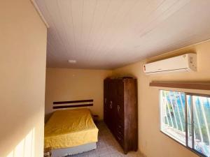a small bedroom with a bed and a window at Duplex em condomínio / Guriri ES in São Mateus