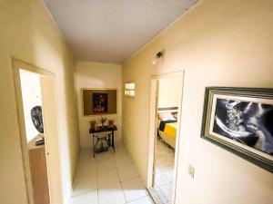 a room with a hallway with a bed and a mirror at Duplex em condomínio / Guriri ES in São Mateus