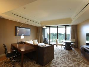 a hotel room with a desk and a living room at Shima Kanko Hotel The Bay Suites in Shima