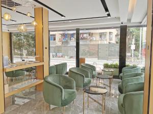 um salão com cadeiras verdes e uma sala de espera em Connar Hotel - Shenzhen Futian em Shenzhen