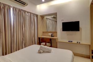 ein Hotelzimmer mit einem Bett und einem Schreibtisch in der Unterkunft JAI MALHAR RESIDENCY in Kālundri