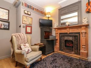 a living room with a fireplace and a chair at The Old Clock Makers in Ashbourne