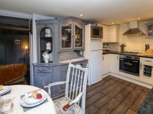 a kitchen with a table and a white refrigerator at The Old Clock Makers in Ashbourne