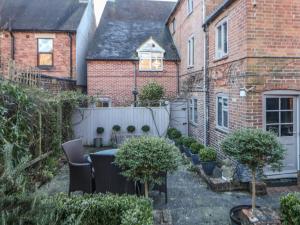 a backyard with a table and chairs and a fence at The Old Clock Makers in Ashbourne
